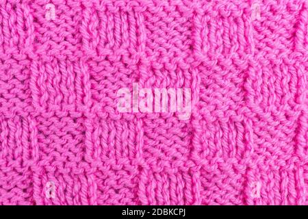 Pink seamless knit pattern. Woolen fabric. Christmas red knitted greeting card template, banner, backgrounds, Wallpaper. Vector illustration. Stock Photo