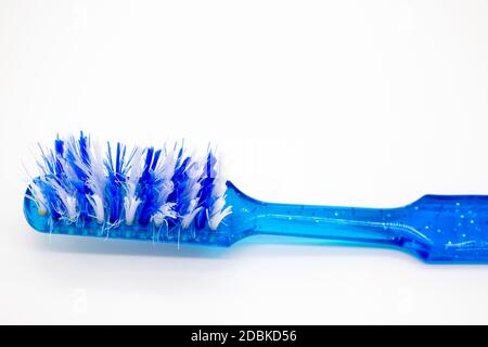 Old blue toothbrush isolated on white background Stock Photo