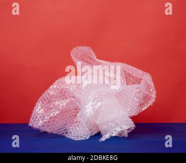 crumpled piece of polyethylene with air bubbles on a blue wooden background, packing material Stock Photo