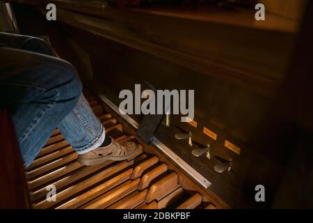 Foot of an organist is playing on the pedal board of a pipe organ in a church, copy space, selected focus, narrow depth of field Stock Photo