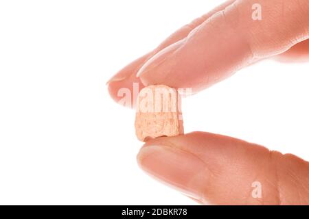 Ecstasy pill in a woman's hand isolated on white background. MDMA therapeutical use. Stock Photo