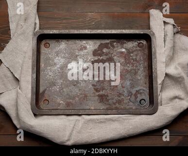 empty rectangular iron rusty baking sheet on a wooden brown table, top view Stock Photo