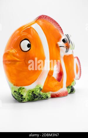 Porcelain piggy bank in the shape of a clown fish on a white background Stock Photo