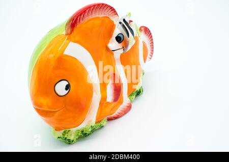 Porcelain piggy bank in the shape of a clown fish on a white