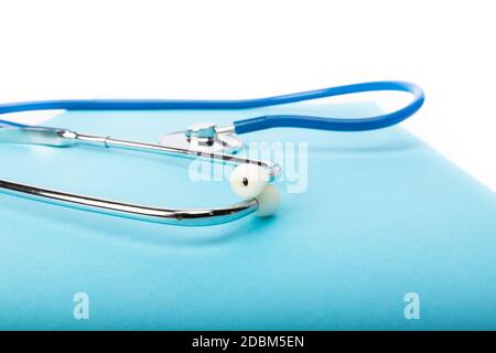 medical record and blue stethoscope close-up on white background in studio Stock Photo