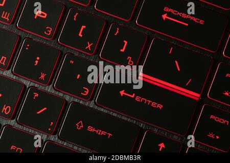 Enter key. Red backlight, backlit on gaming laptops computer in the dark. Close up. Stock Photo