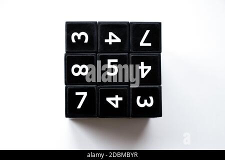 Black cube with numbers in its area for playing the Japanese Sudoku game on a white background Stock Photo