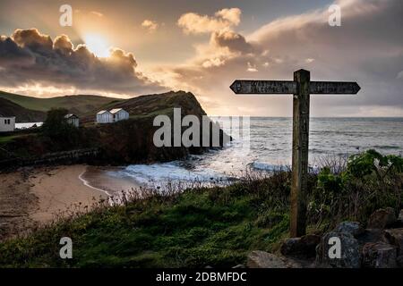 Low evening light illuminates Hope Cove beach, which is in the South Devon area of Outstanding Natural Beauty on an autumn evening. Stock Photo
