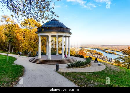 Rudesheim am Rhein in upper middle Rhine river valley (Mittelrhein). by Germania monument (Niederwalddenkmal), yellow autumn, blue sky. Panorama view. Stock Photo