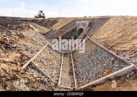 Construction of a drainage ditch along a new road being built Stock Photo