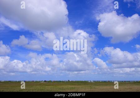 Panorama an der Nordsee von Dünen mit Strandkörben und Wolken am blauen Himmel Stock Photo