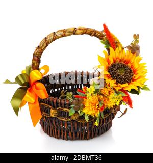 Original dark brown wicker basket with floral decoration on white background. Decor of yellow flowers and large sunflower flower. Ukrainian style East Stock Photo