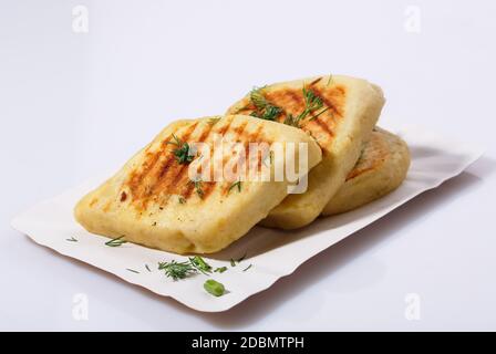 Fried potato pies. Patties with dill. Cheap recipe for homemade fried pies on a white background. Easy meal idea. Side view. Stock Photo