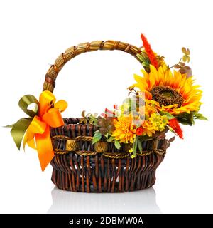 Original dark brown wicker basket with floral arrangements. Great scenery with yellow flowers, greenery and a large sunflower flower. Shopping cart in Stock Photo