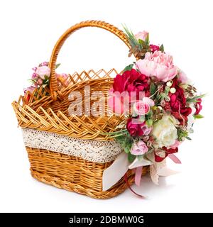 Very beautiful original brown wicker basket decorated with pink and white peonies. Ribbons and lace. Side view. Stock Photo