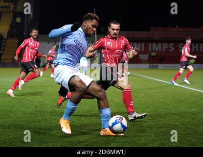 Lincoln City’s Remy Howarth and Manchester City's Jayden Braaf (left) battle for the ball during the Papa John's Trophy match at Sincil Bank, Lincoln. Stock Photo