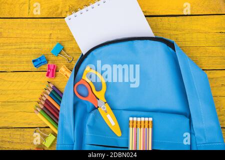 Top view flat lay of blue school bag backpack and accessories tools for children education on yellow wood background, Back to school concept and have Stock Photo