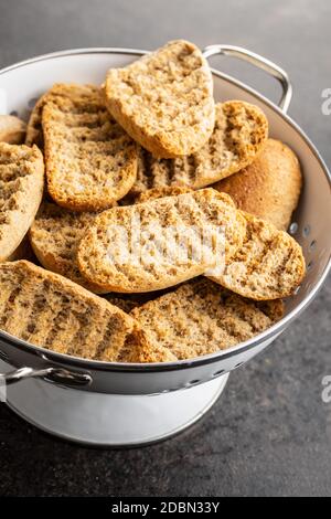 Rusk bread. Dried crispbread in colander. Stock Photo