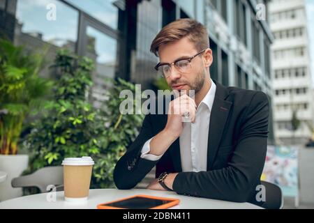 Handsome young businessman in eyeglasses looking concentrated Stock Photo