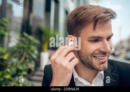 Handsome man wearing wireless headphones and smiling Stock Photo