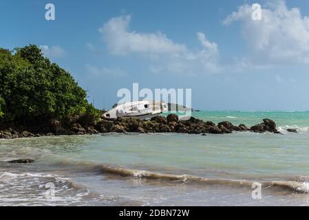 A Sailboat was destroyed and abandoned on the shore after a hurricane - the Gosier in Guadeloupe, Caribbean Stock Photo