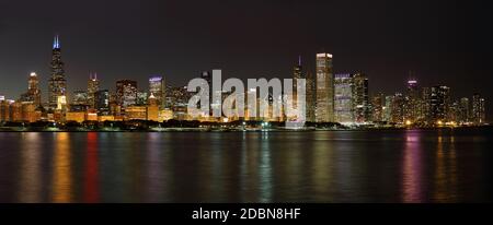 The Chicago skyline and waterfront at night with illuminated buildings reflected in the water of Lake Michigan Stock Photo