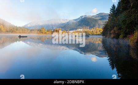 Fog rises off of One Mile Lake on a crisp fall morning in Pemberton, British Columbia. Stock Photo