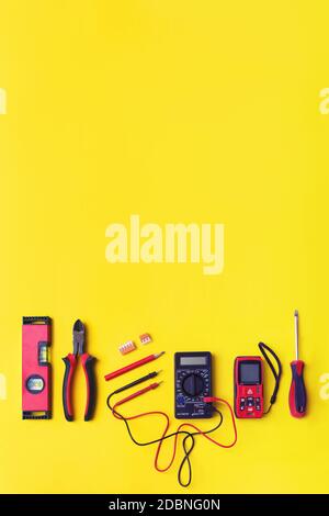 Set of electrician's tools on yellow background. Flat lay composition with electrician's tools and space for text yellow background Stock Photo