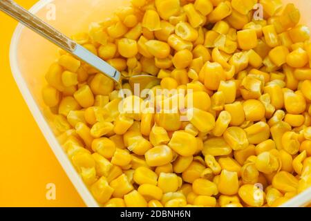Cooked sweetcorn kernels in a plastic container. Close up. Stock Photo