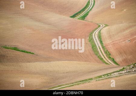 winding road through dry landscape between Ronda and Sevilla, Spain Stock Photo