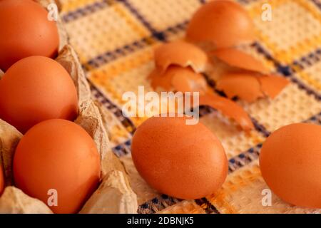Brown chicken egg on vintage tablecloth and eggs in the basket. Stock Photo