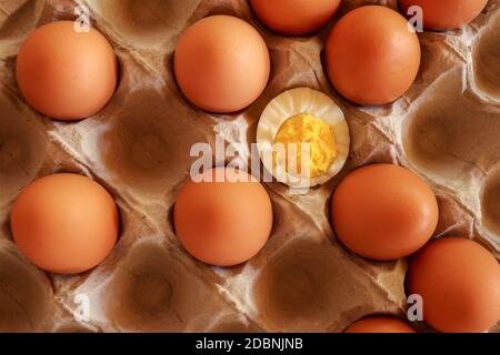Eggs in paper tray. one soft-boiled. view from top.Boiled halved eggs. Stock Photo