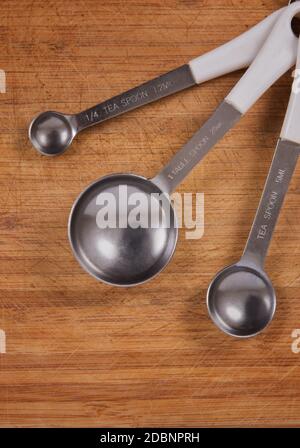 tea spoons over wooden kitchen table Stock Photo