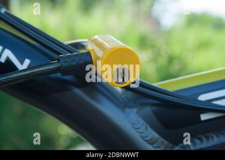 Yellow plastic lock fixed on a bicycle close up Stock Photo