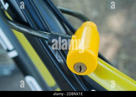 Yellow plastic lock fixed on a bicycle close up Stock Photo