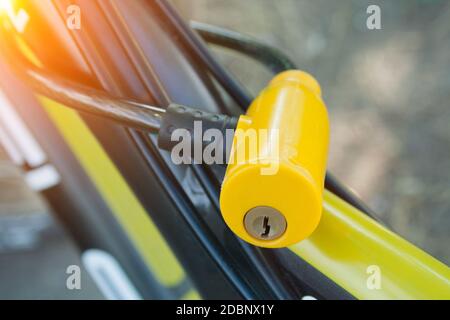 Yellow plastic lock fixed on a bicycle close up Stock Photo