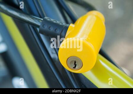 Yellow plastic lock fixed on a bicycle close up Stock Photo