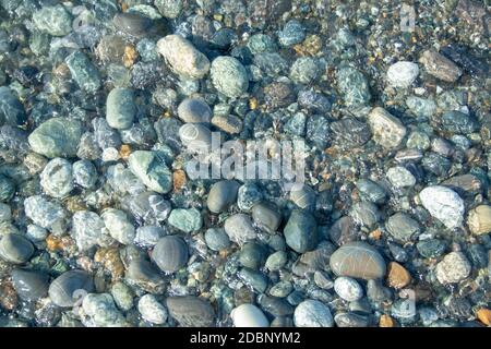 Stone beach with waves. Multi colore stones on beach Stock Photo