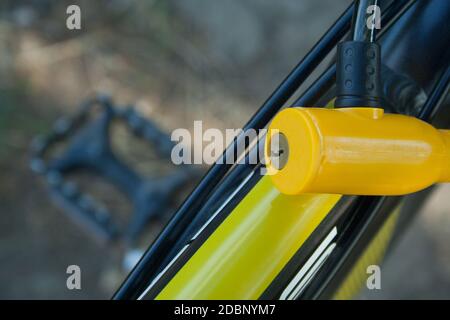 Yellow plastic lock fixed on a bicycle close up Stock Photo