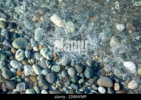 Stone beach with waves. Multi colore stones on beach Stock Photo