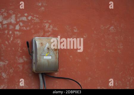 Old power box on red wall. Old electric box Stock Photo