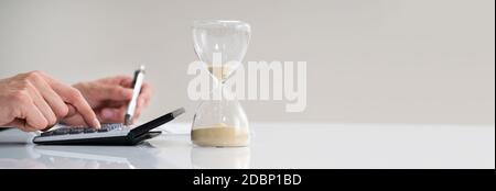 Late Invoice And Hourglass Deadline Working In Office Stock Photo