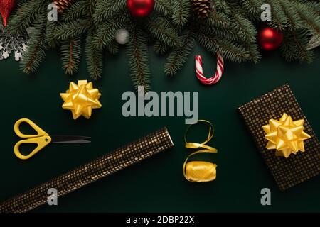 On a table decorated with Christmas decor, there are items needed for gift wrapping. Stock Photo