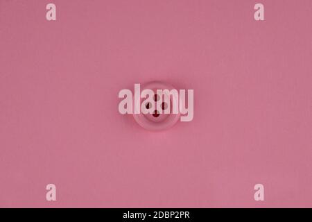 Minimal pink background with pink button in middle. Flat lay Stock Photo