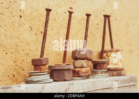 Organized old rusty nuts on grunge and aged nails on wooden background. Concept of work and construction Stock Photo