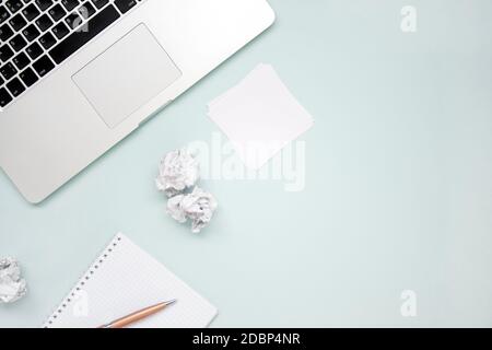 Work and creativity concept. Laptop, notepad, crumpled paper and pen top view flat lay photo with copyspace. Computer and paper work. Office paper wor Stock Photo