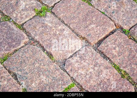 Old aged granite paving stones. Texture of old granite paving stones. The texture of the pavement granite pattern wallpaper for design. Rough texture Stock Photo