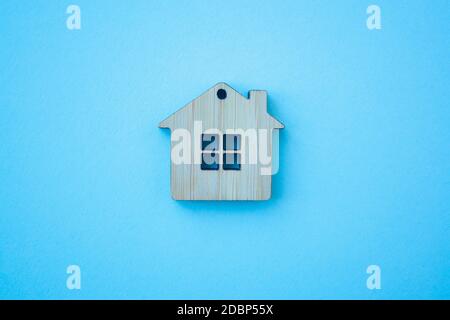 House, insurance and mortgage, buing and rent concept. Small wooden house toy on blue background top view Stock Photo