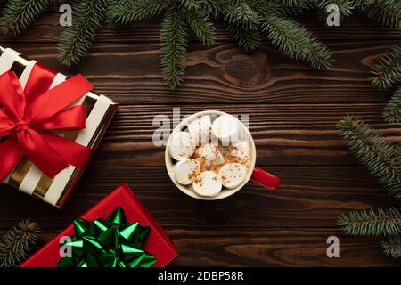There is a cup of hot chocolate with marshmallows on a table decorated with Christmas decor. Stock Photo