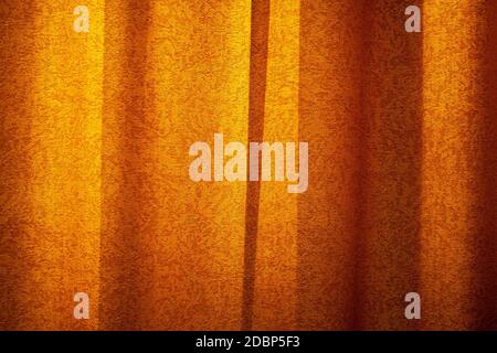 Red curtain background in sunset light. Curtain cloth texture dark Stock Photo